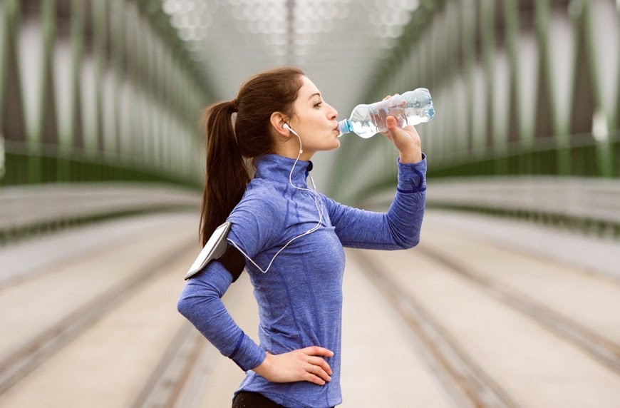 GettyImages-woman-drinking-water-workout-Halfpoint
